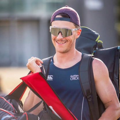 An athlete wearing sleek sport sunglasses confidently strides towards their training session, embodying focus and determination on their journey to excellence.